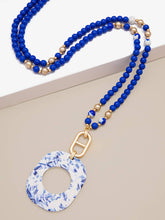 Load image into Gallery viewer, Emblem Charm And Porcelain Pattern Acetate Pendant Necklace: Cobalt
